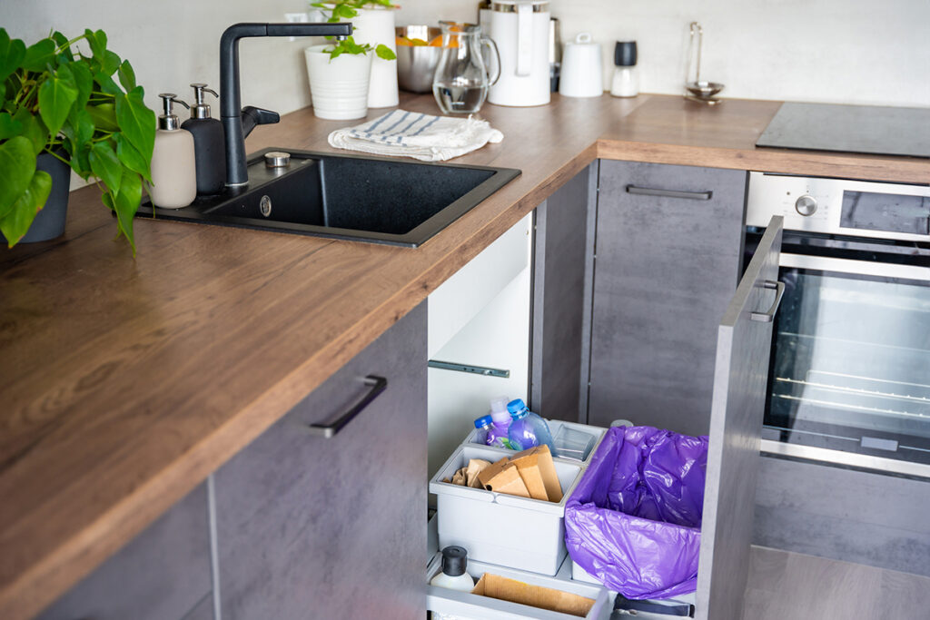 kitchen cabinet with hidden trash and recycling bins