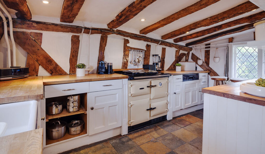 Heavily beamed kitchen within a 16th Century English cottage fitted with traditional style cupboards